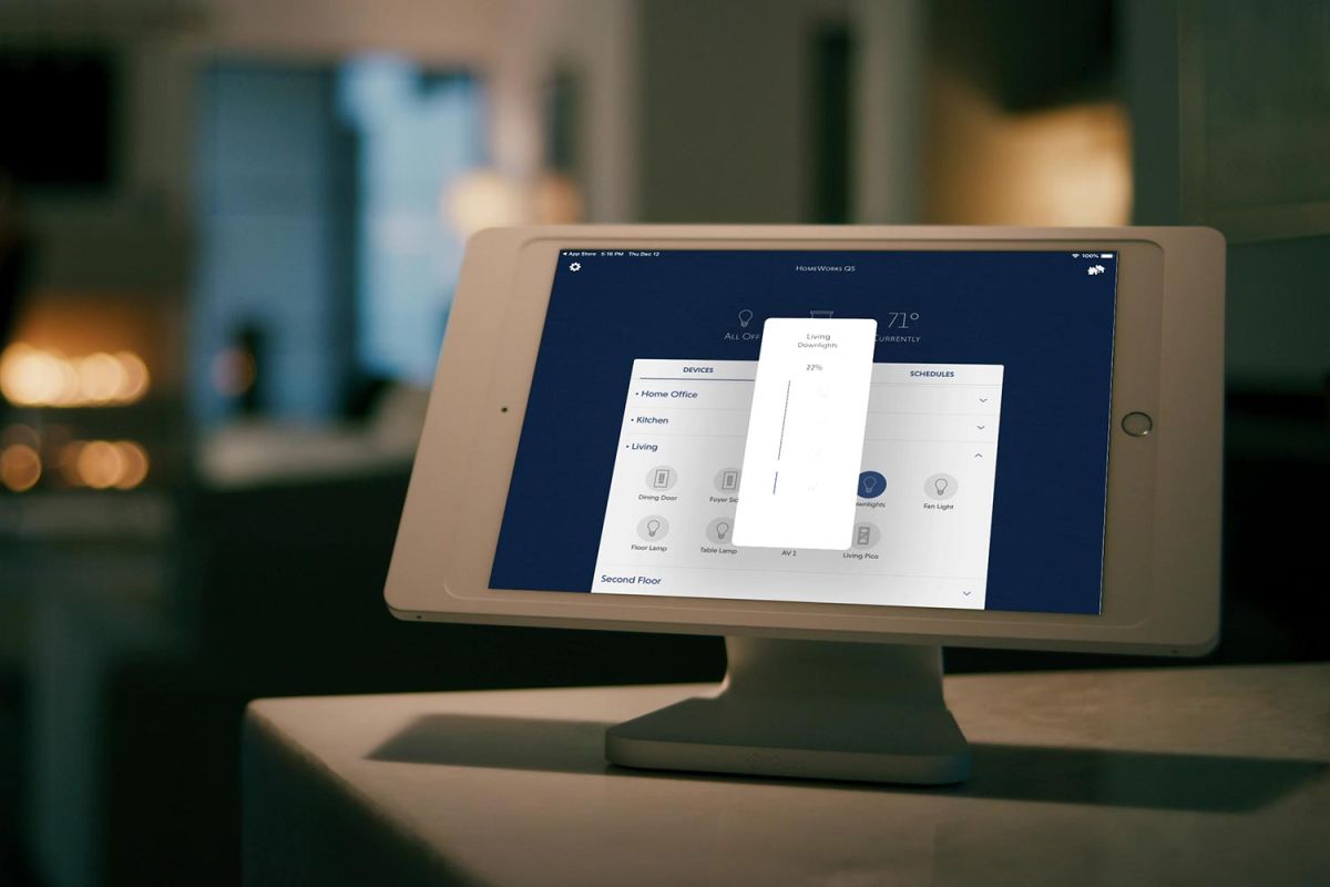 A tablet displaying a home automation interface in a dimly lit room.